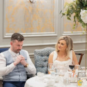 Bride and groom sit together at their wedding reception table at Newpark Hotel Kilkenny, sharing a quiet moment surrounded by candlelight, florals, and elegantly set tableware.