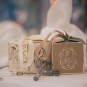 Elegant dining table setting with gift boxes, wine glass, and candlelight for a romantic hotel stay.