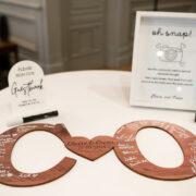 Elegant hotel table with guestbook and vintage camera for capturing wedding memories.