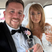 Elegant couple celebrating with champagne in luxury hotel suite.