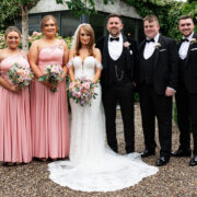 Bridesmaids and groomsmen with the married couple pose in a lush garden setting at a beautiful hotel. Perfect venue for weddings.