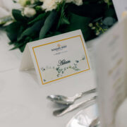 Elegant table setting in luxury hotel dining room, featuring a personal name card and floral centrepiece.