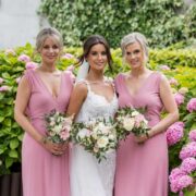 Elegant wedding party in lush garden with vibrant pink hydrangeas, highlighting our stunning outdoor venue.