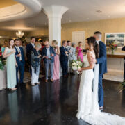 Elegant wedding reception in a luxurious hotel ballroom with chandeliers and guests enjoying the celebration.