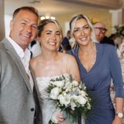 Guests smiling at elegant hotel event with floral decor and soft lighting, ideal for weddings and celebrations.