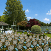 Elegant outdoor wedding venue with garden gazebo surrounded by lush greenery and floral arrangements.