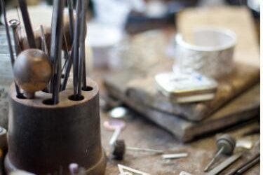 Luxurious hotel's artisan workshop showcasing intricate metal crafts amidst creative tools.