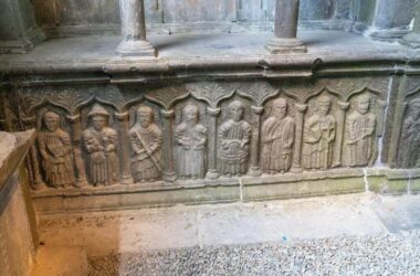 Historic stone carvings in serene hotel courtyard, showcasing medieval figures and intricate details, enhancing cultural ambiance.