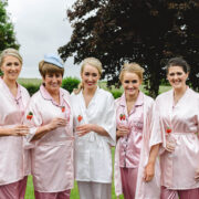 Guests in matching robes enjoy drinks in a lush garden, ideal for relaxed weddings or celebrations at our countryside hotel.