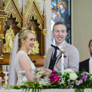 Elegant wedding ceremony in ornate chapel, vibrant floral arrangements, joyful couple exchanging vows.