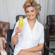 Guest enjoying a mimosa in elegant room with plush chairs, adding a touch of luxury to the hotel experience.