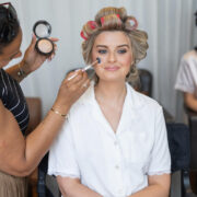 Guest enjoys professional makeup service in hotel suite with soft lighting, creating a relaxing pre-event atmosphere.