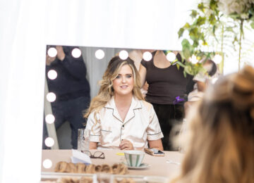 Guest enjoys a relaxing morning with coffee in a cosy hotel suite featuring a luxurious vanity mirror.
